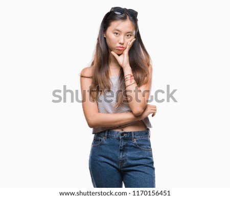 Young asian woman wearing sunglasses over isolated background thinking looking tired and bored with depression problems with crossed arms.