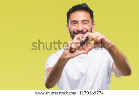 Adult hispanic man over isolated background smiling in love showing heart symbol and shape with hands. Romantic concept.