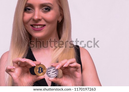 golden bitcoin and silver litecoin in the hand of a beautiful blonde girl 