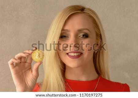 golden bitcoin in the hand of a beautiful blonde girl 