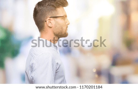 Young handsome man over isolated background looking to side, relax profile pose with natural face with confident smile.