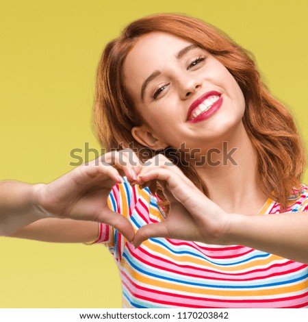 Young beautiful woman over isolated background smiling in love showing heart symbol and shape with hands. Romantic concept.