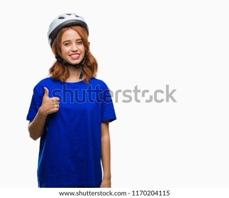 Young beautiful woman wearing cyclist helmet over isolated background doing happy thumbs up gesture with hand. Approving expression looking at the camera with showing success.
