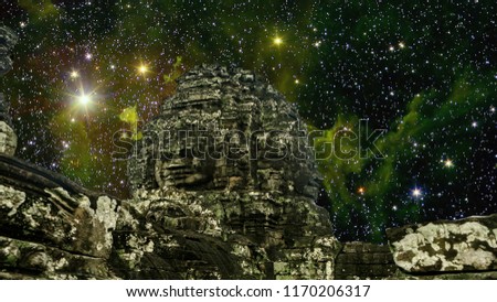 Famous Bayon temple in Siem Reap, Cambodia, Asia faces view  at night with amazing star formations, nebulas on the background. Elements of this image furnished by NASA.