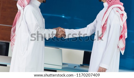 Middle eastern businessmen shaking hands, in an office environment Royalty-Free Stock Photo #1170207409