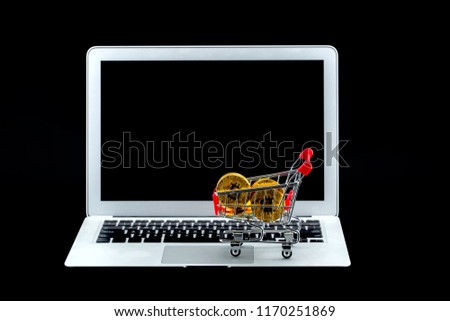 Shopping carts with gold bitcoin on laptop computer isolated on black background, digital currency money trading with cryptocurrency, coin with profit, finance concept.