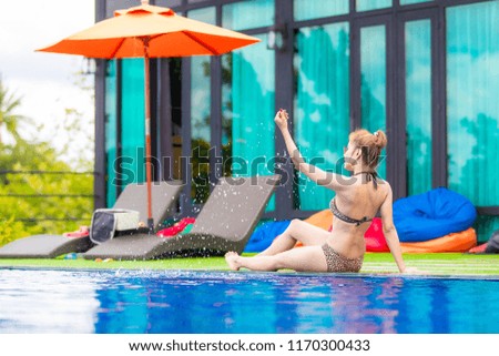 Woman in bikini relaxing on the swimming pool. Summer concept
