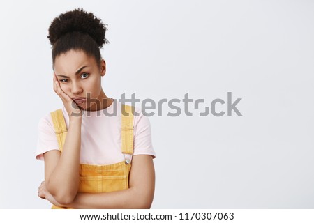Woman hates when friend complaining on her life, staring with indifferent and bored expression, leaning on palm, frowning and pouting, being tired and annoyed over gray background Royalty-Free Stock Photo #1170307063