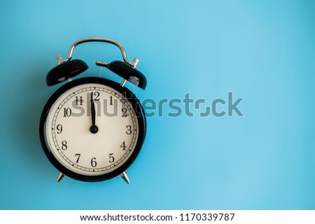 Festive holiday New Year and Christmas blue background with alarm clock. Flat lay. Top view.