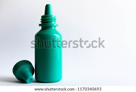 Green plastic eye dropper bottle isolated on white background.