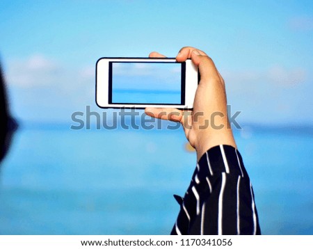 Girl hand taking photo at beach