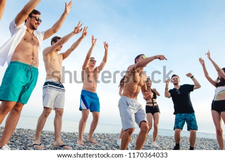 Friends funny dance on beach under sunset sunlight, having fun, happy, enjoy