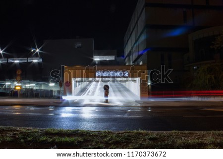 Entry to parking place in night with car trail, long exposure
