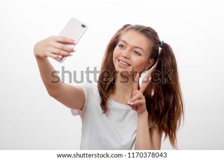 positive hipster girl wearing two ponytails showing victory sign while taking selfie, isolated white background, sign, gesture, happiness concepts