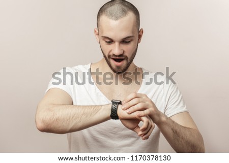 happy young excited surprised man learning to use smartwatch. new opportunities of digital watches. technology, device concept