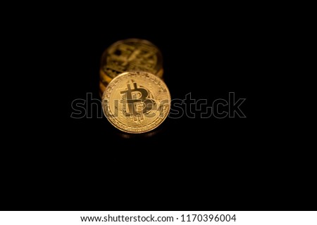 Stack of golden bitcoins isolated on black background with reflection. Cryptocurrency concept with copy space.
