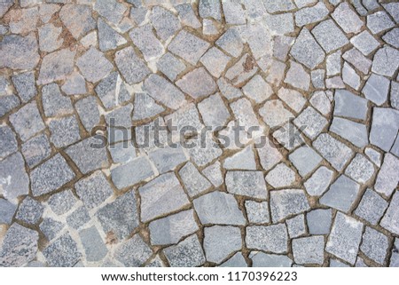 City street stone pavement. Top view on cobblestoned pavement background. Abstract background of old cobblestone pavement street