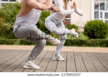 summer holidays, vacation activities, love and sport lifestyle concept - happy young couple in activewear sitting on green meadow in Lotus position, meditating, feeling comfortoble and free