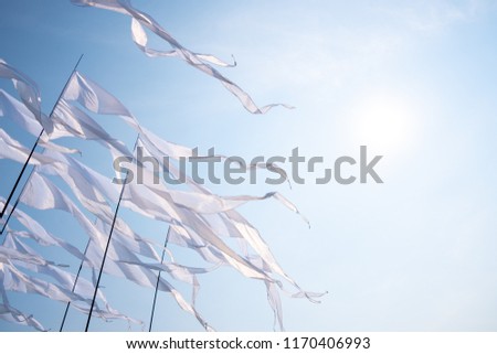 Triangular white banner against the blue sky.