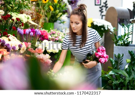 Picture of cute young florist picking flowers for bouquet
