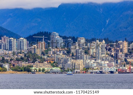 Vancouver North Shore skyline and waterfront cityscape with Grouse mountain on a cloudy day in British Columbia, Canada
