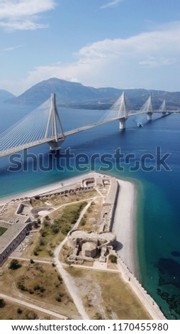 Aerial bird's eye drone photo of iconic Castle in Rio and state of the art suspension bridge crossing Rio and Antirio at the background, Patra, Peloponnese, Greece