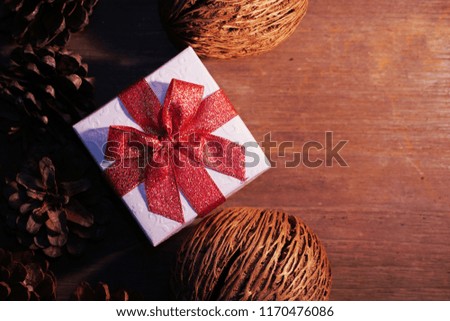 Topview white gift box with red ribbon with group of pine cones, picture have space for idea.