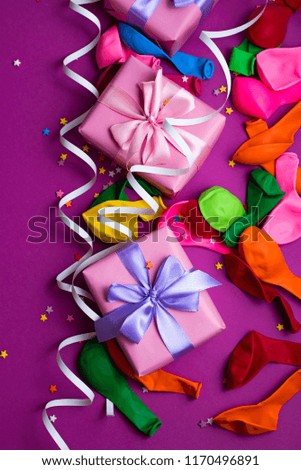 Festive background of purple material colorful balloons streamers confetti box gift. Top view flat lay copy space