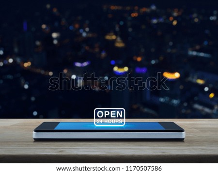 Open 24 hours icon on modern smart mobile phone screen on wooden table over blur colorful night light city tower and skyscraper, Business full time service online concept