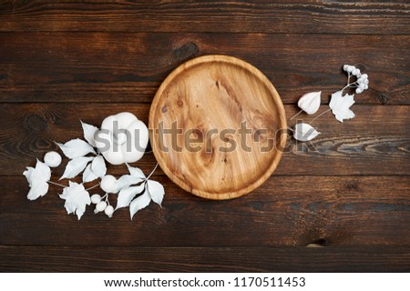 Autumn decor with white leaves and pumpkin with wooden place on dark brown wooden backgound flat lay mockup for your art, picture or hand lettering composition copy space, top view