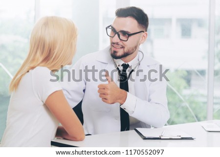 Male doctor is talking with female patient in hospital office. Healthcare and medical service.