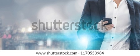 Young businessman using mobile phone with modern city buildings background. Future telecommunication technology and internet of things ( IOT ) concept.