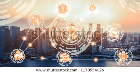 Smart city wireless communication network with graphic showing concept of internet of things (IOT) and information communication technology (ICT) against modern city buildings in the background.