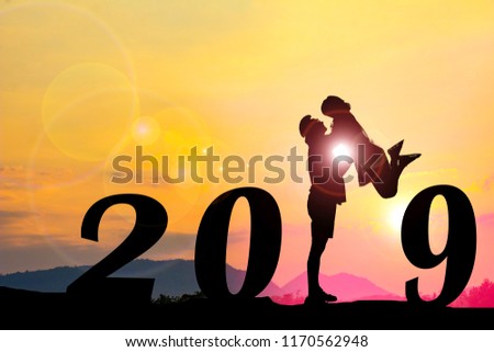 Happy new year Silhouette sunset background.Man standing and  lift woman.They are standing instead  number 1 word and standing between 20 and 9.new year,2019,love,Photo Silhouette and new year