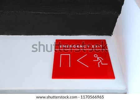 Fire emergency exit sign on a white wall.