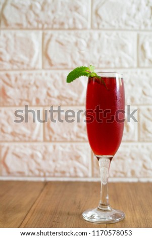 Glass of pomegranate juice garnish with mint leaves on wooden table
