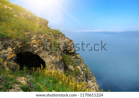 Cave in a rock by the sea. Above the water you can see the fog. Beautiful landscape.