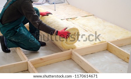 worker insulates the floor with mineral wool Royalty-Free Stock Photo #1170614671