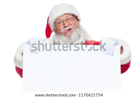 Christmas. Kind Santa Claus in white gloves with his tongue sticking out holds an empty white cardboard and shows faces, grimaces. Place for advertising, for text, empty space. Copy-paste. Isolated on