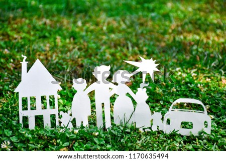 Paper family, house and car on a green grass. Family Life Insurance, protecting family, family  and love concepts. Concepts saving money for house or car. Mortgage and auto lending. Ecology concept.

