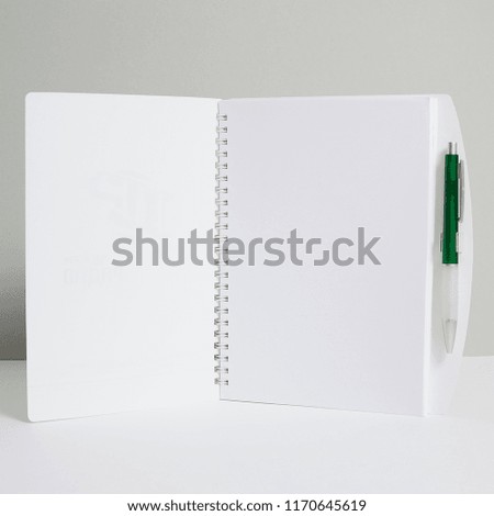 Open notebook with pen on white background