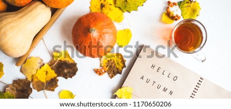 Hello, Autumn. Orange pumpkins Notepad Cup of tea Autumn foliage on a wooden background