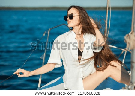 Girl sitting on the bow of a sailboat, ship