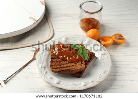 Toasted bread with delicious apricot jam on plate