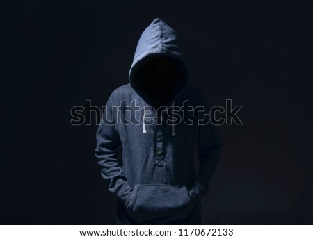 Mysterious man with hoodie in silhouette on black background. committed a crime concept.  Royalty-Free Stock Photo #1170672133