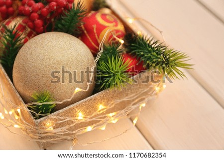 Box with Christmas decorations on white wooden table, closeup