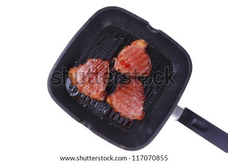 fresh grilled bloody beef steaks on black grill plate isolated on white background