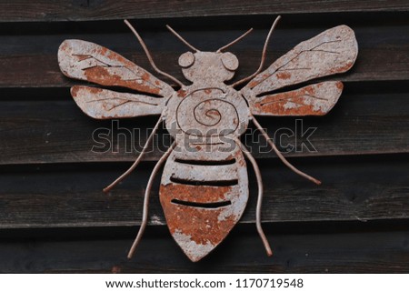 Steel decoration of bees on a wooden background