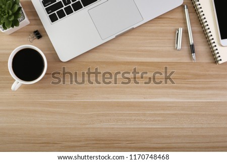 Wood office desk table with laptop, cup of coffee and supplies. 