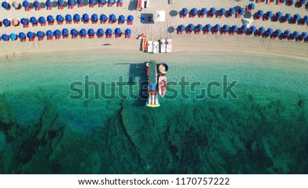 Aerial drone photo of mediterranean island sandy beach with emerald sea and watersports facilities